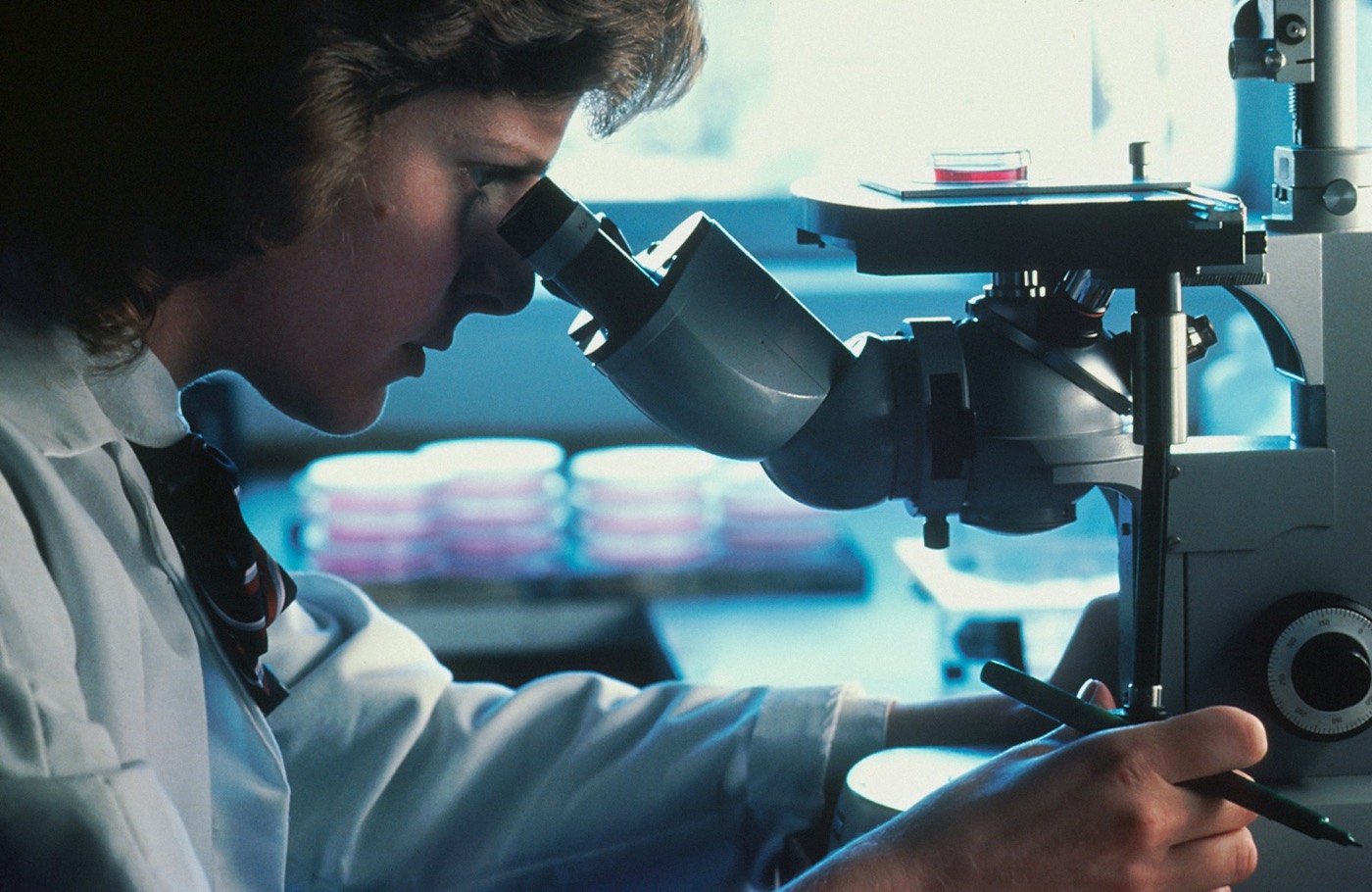 A researcher looking through a microscope in a laboratory